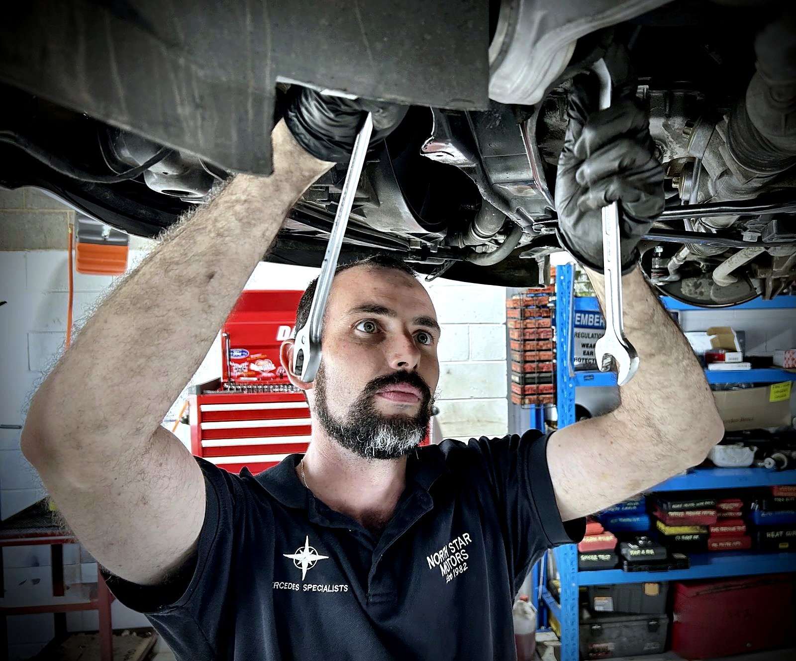 North Star Motors technician working underneath a car on the hoist